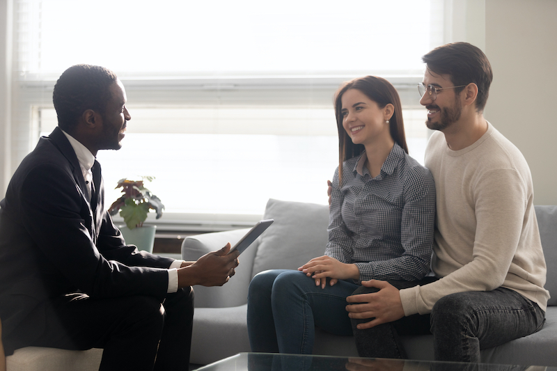 Why you need a real estate agent in New York City: an agent meeting with homebuyers to discuss buying a home in NYC.