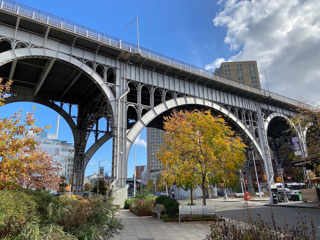 Riverside Drive Viaduct in West Harlem with steel arches over 125th Street, autumn trees, and surrounding Manhattanville buildings in New York City