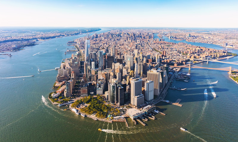 Difference between MLS listings and RLS listings in NYC illustrated by an aerial view of Lower Manhattan and New York Harbor.
