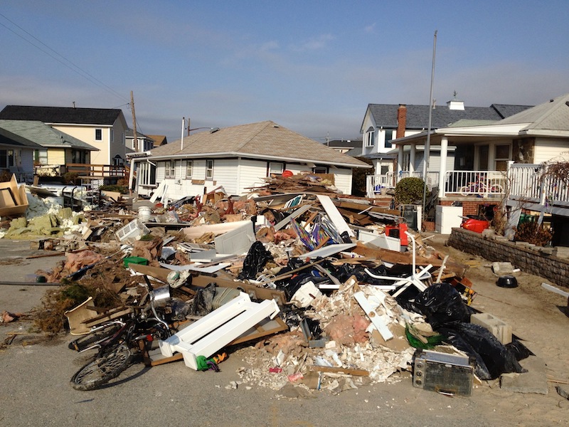Aerial view of homes on a coastline with digital overlay showing climate risk zones such as flooding