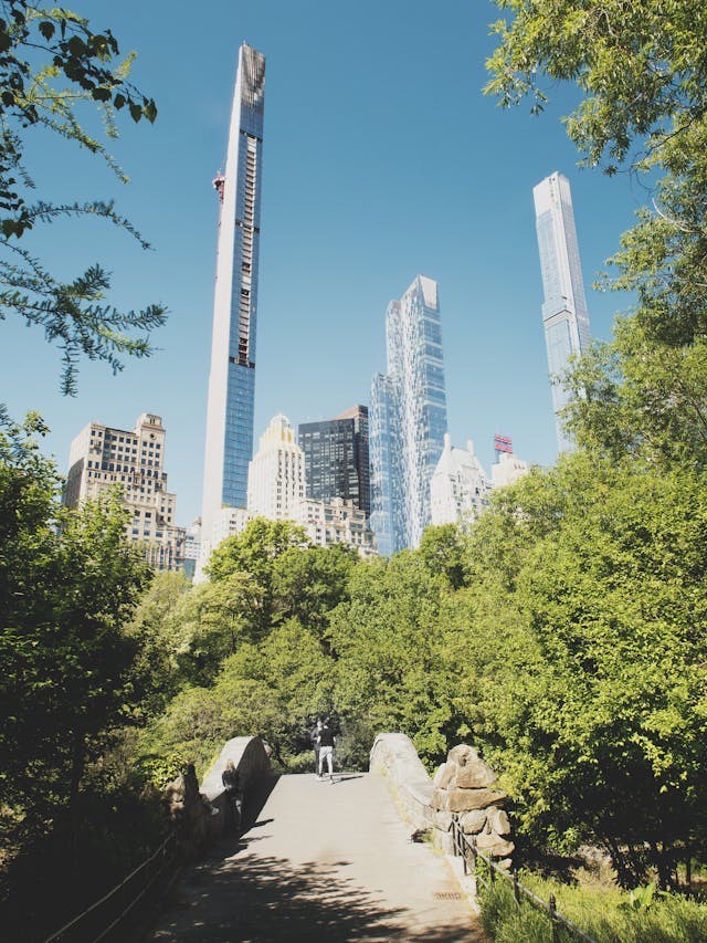 Central Park pathway with Billionaires’ Row supertall towers rising above Manhattan skyline