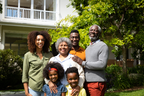 Multigenerational family standing in front of a home representing inheritance, estate administration, homeownership, and generational wealth in New York.